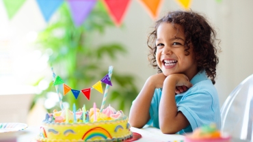 child smiling at a birthday cake