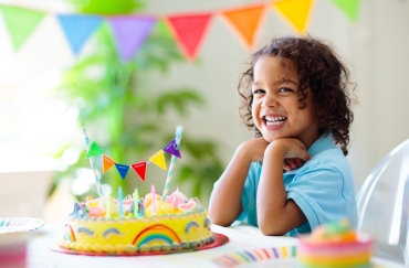 child smiling at a birthday cake